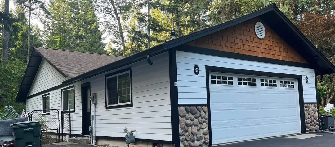 Rambler repainted white with black trim and a cedar-shingle gable by Premier Paint & Construction